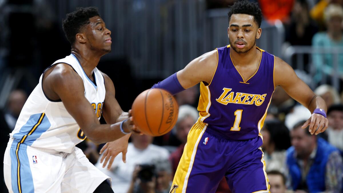 Nuggets guard Emmanuel Mudiay makes a pass against the defense of Lakers guard D'Angelo Russell during a game March 2 in Denver.