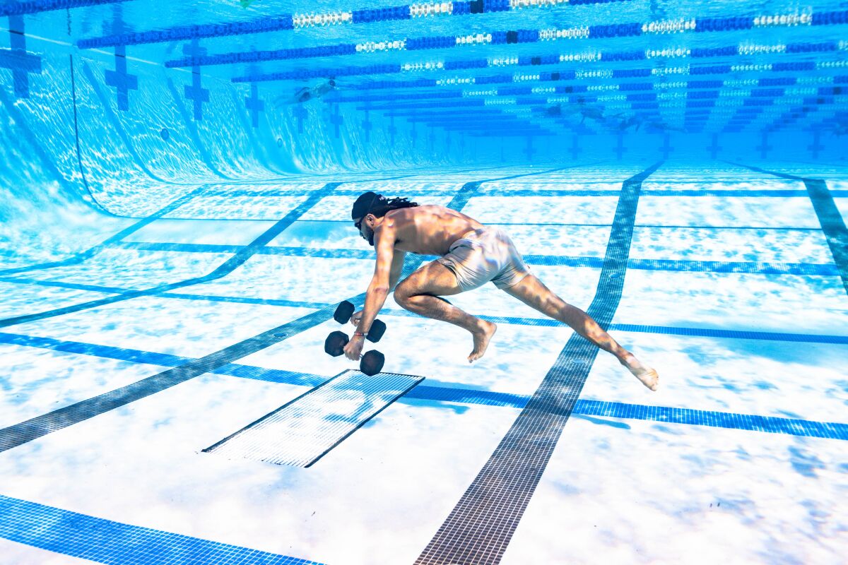 Fernando Tatis Jr. walks across the bottom of a La Jolla pool while carrying weights, part of his offseason training program.