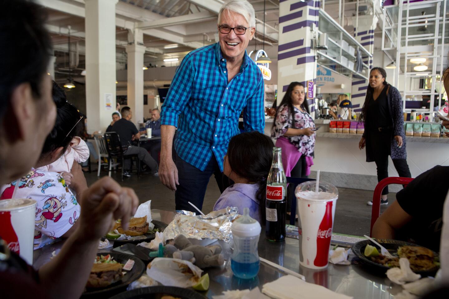 George Gascon, candidate for Los Angeles County district attorney, greets a family at Grand Central Market during lunch hour in downtown Los Angeles.