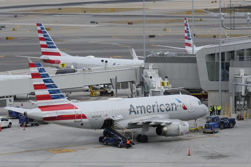 FILE - American Airlines planes sit on the tarmac at Terminal B at LaGuardia Airport, Jan. 11, 2023, in New York. American Airlines is raising bag fees and pushing customers to buy tickets directly from the airline if they want to earn frequent-flyer points. American said Tuesday, Feb. 20, 2024, that checking a bag on domestic flights will rise from $30 now to $35 online, and it'll be $40 if purchased at the airport. (AP Photo/Seth Wenig, File)