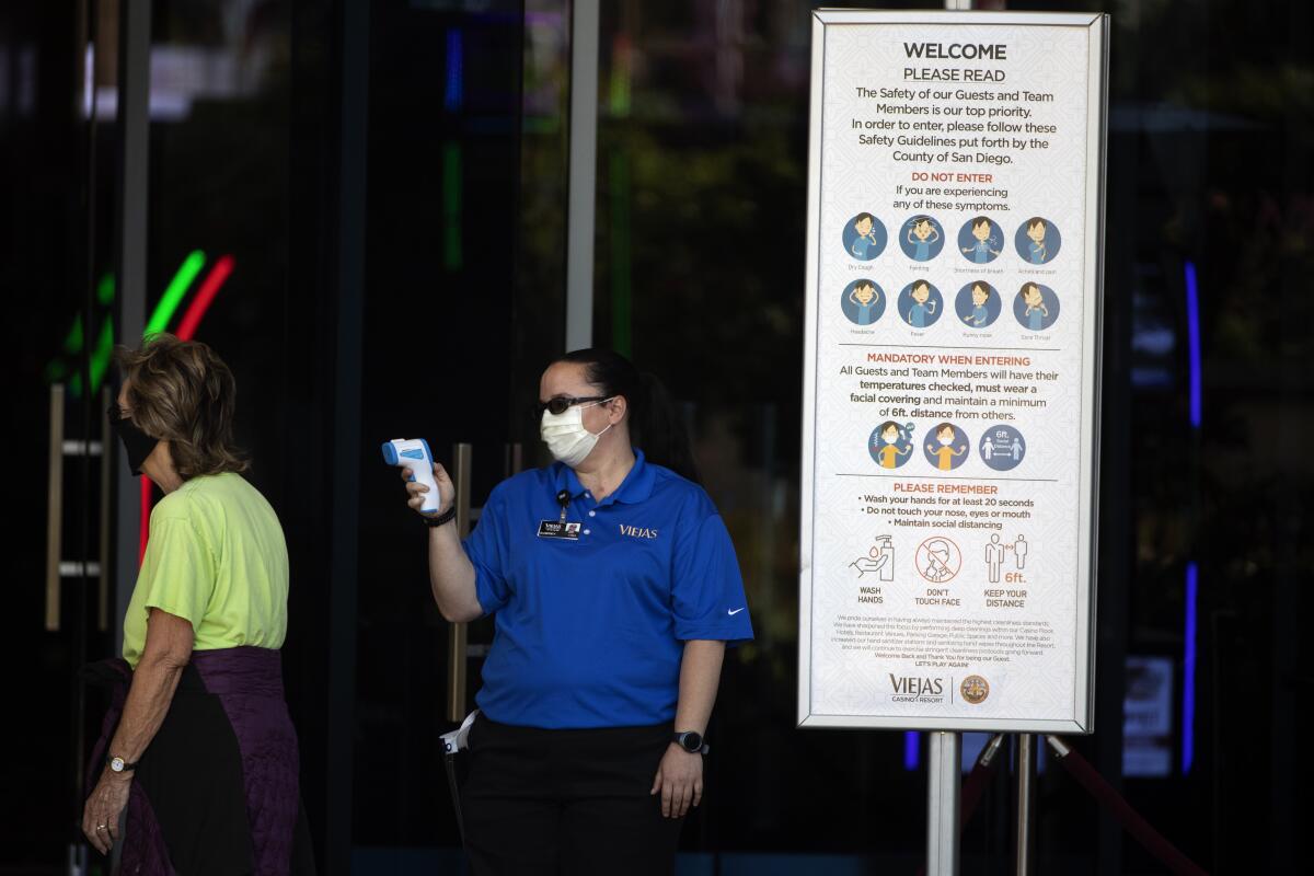 An official reads the temperature of a woman at the Viejas Casino and Resort in Alpine, Calif. 