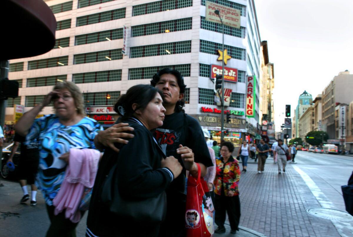 Una pareja pasea en la 7th y Broadway un área donde los latinos suelen hacer sus compras.