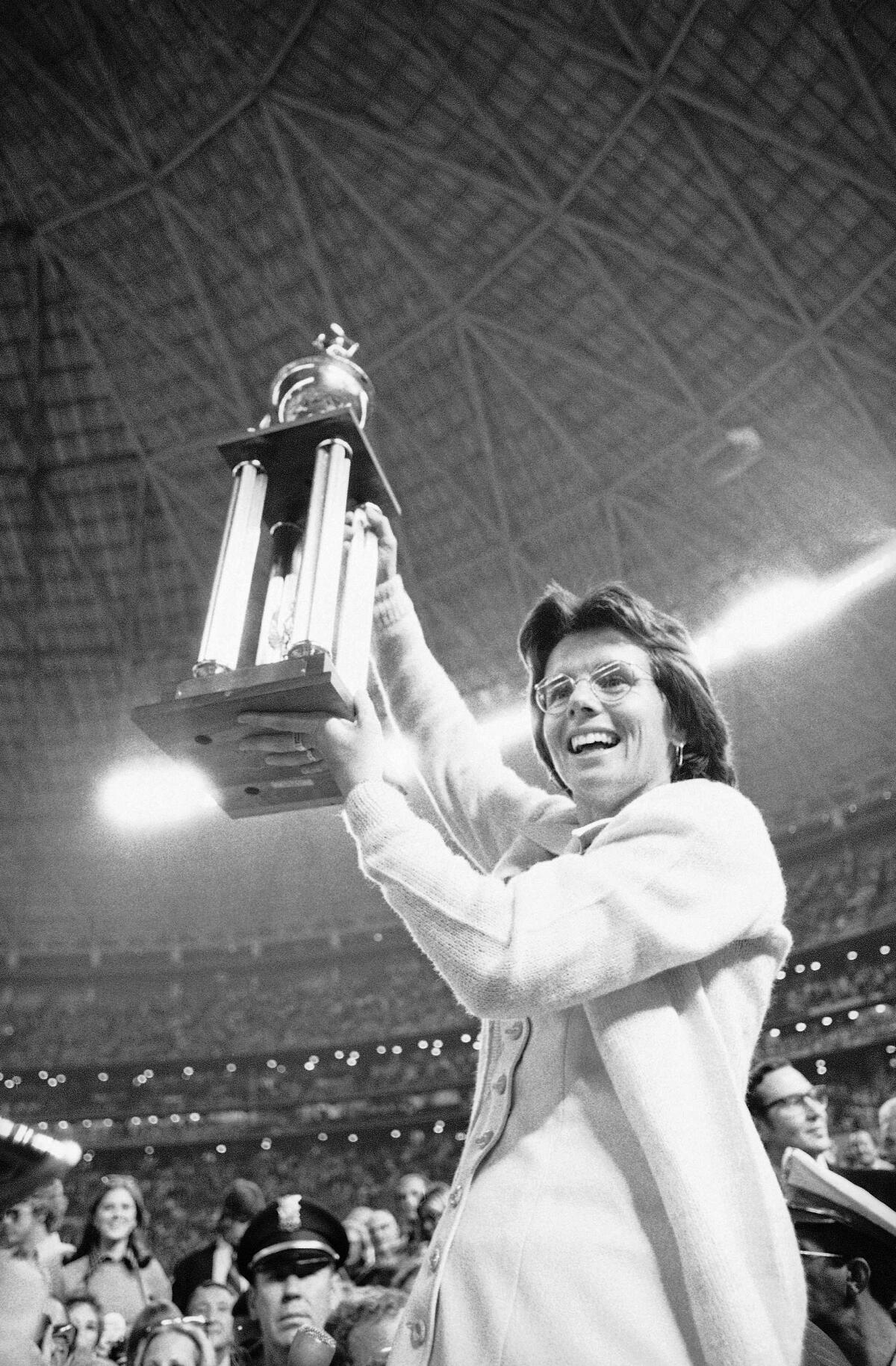 Billie Jean King holds up the winner's trophy after defeating Bobby Riggs at the Astrodome in Houston.