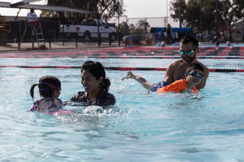 Abigail Lum and Randy Lum play with their children, Emilia, 3, and Miles, 4, at Bud Kearns Municipal Pool at Morley Field Sports Complex in Balboa Park on Saturday, March 26, 2022.