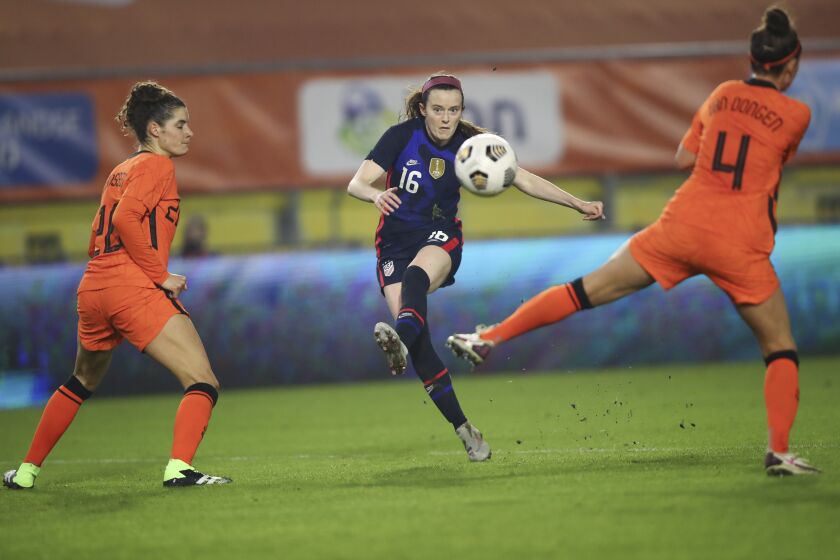 United States' Rose Lavelle, center, scores her side's first goal passing Netherlands' Merel van Dongen, right, and Netherlands' Dominique Janssen, left, during the international friendly women's soccer match between The Netherlands and the US at the Rat Verlegh stadium in Breda, southern Netherlands, Friday Nov. 27, 2020. (Dean Mouhtaropoulos/Pool via AP)