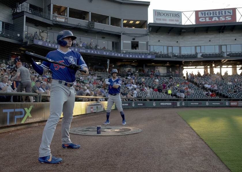 Oklahoma City shortstop Gavin Lux (55) limbers up in front of the dugout before leading off a 2019 Pacific Coast League game