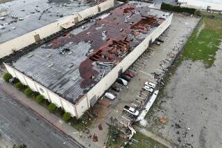 Montebello, CA - March 22: Crews start to clean up debris after a strong microburst -- which some witnesses dubbed a possible tornado -- which injured one person and heavily damaged several cars and buildings, including the roof of the Royal Paper Box Company, shown in photo, in Montebello Wednesday, March 22, 2023. Five buildings have been damaged and one has been red-tagged. Video from the scene showing portions of rooftops being ripped off industrial structures and debris swirling in the air. The National Weather Service on Tuesday night issued a brief tornado warning in southwestern Los Angeles County, but it was allowed to expire after about 15 minutes when weather conditions eased. There was no such warning in place late Wednesday morning when the powerful winds hit Montebello, near the area of Washington Boulevard and Vail Avenue. (Allen J. Schaben / Los Angeles Times)