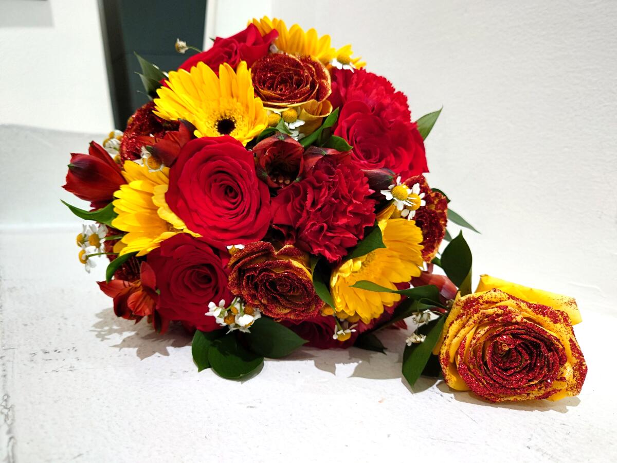 A bouquet of red and gold flowers for a wedding