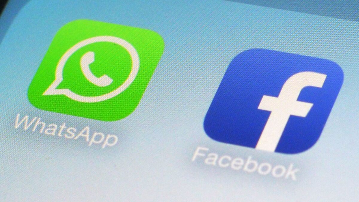 WhatsApp and Facebook icons on a smartphone screen.