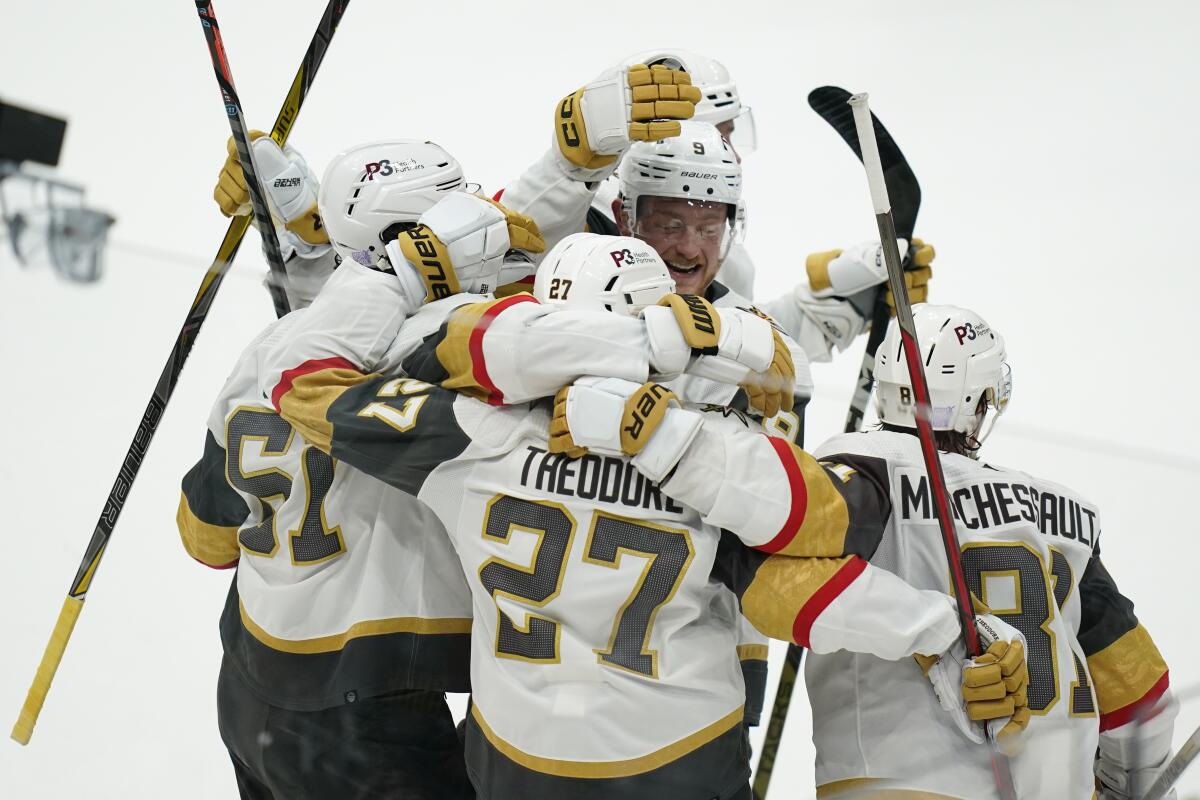 Vegas Golden Knights' Shea Theodore (27) celebrates his goal with teammates during overtime in an NHL hockey game, Tuesday, Nov. 1, 2022, in Washington. The Golden Knights won 3-2. (AP Photo/Patrick Semansky)