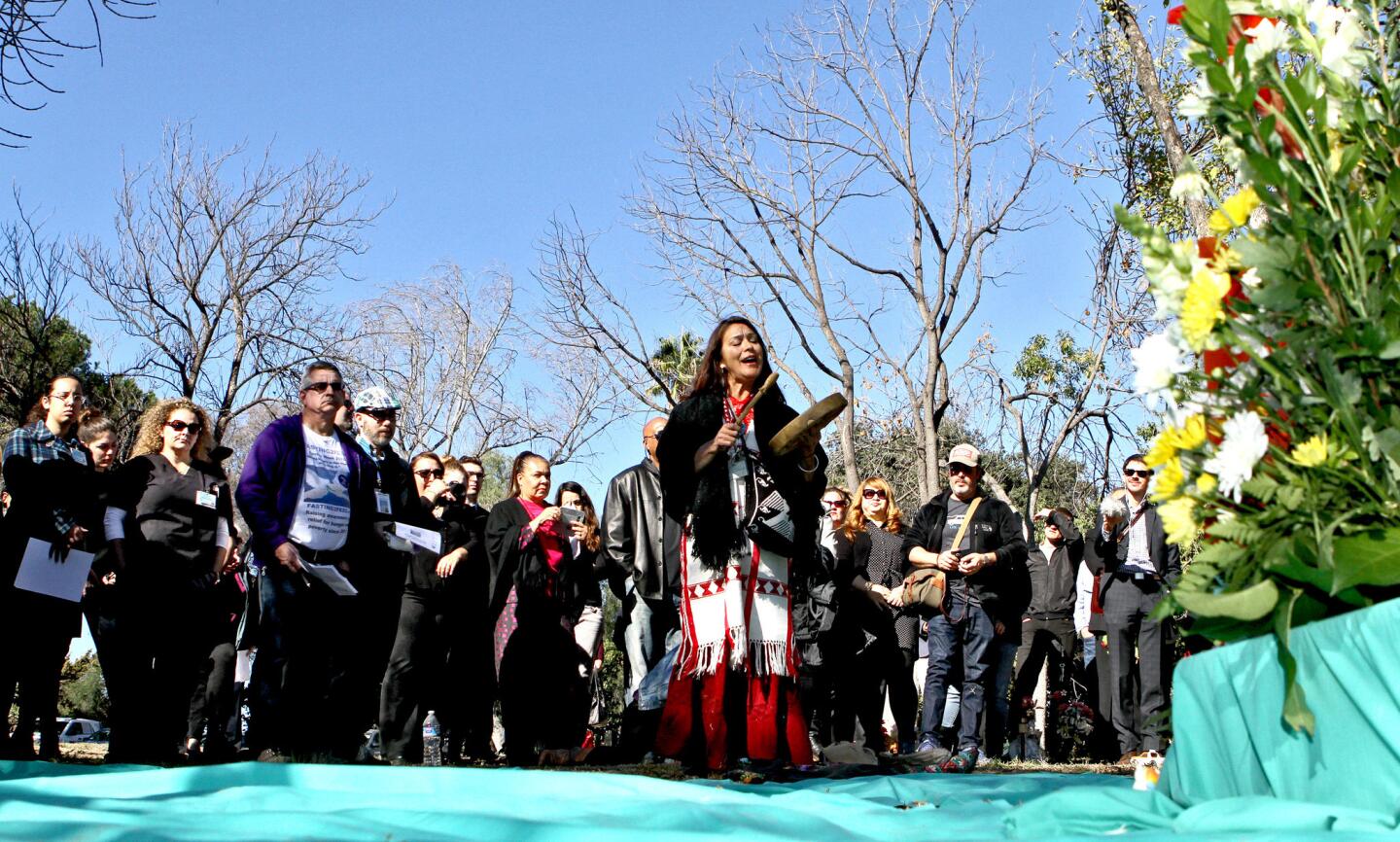 Raquel Salinas performs a Native American song after doing a Native American sage blessing during the annual Los Angeles County Burial of the Unclaimed Dead interfaith ceremony at the L.A. County Cemetery in Boyle Heights on Wednesday, November 30, 2016. The cremains of 1,430 individuals who died and were cremated in 2013 were buried in a single mass grave a few days before. There is a 3-year wait between death and burial to allow family members to come forward to claim the cremated remains before burial. L.A. County has been conducting burials for the unclaimed dead since 1896.