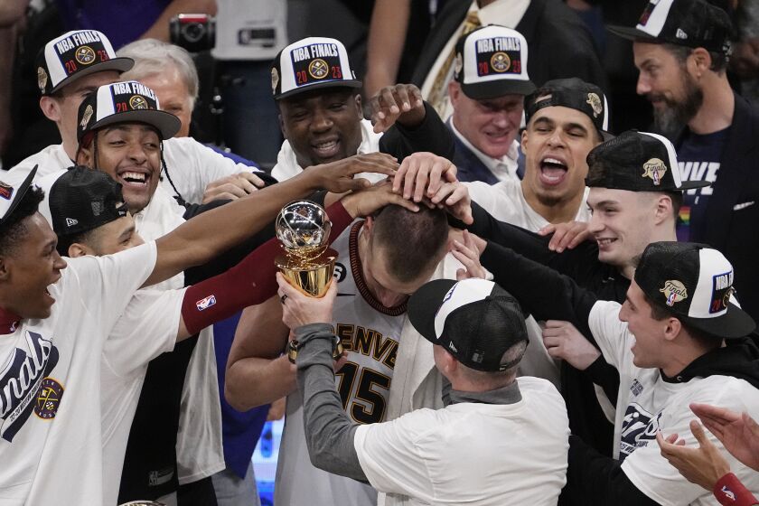 El pívot de los Nuggets de Denver Nikola Jokic recibe palmadas en la cabeza tras recibir el trofeo de MVP de las finales de conferencia al superar a los Lakers de Los Ángeles en el juego 4 de las finales de la Conferencia Oeste el lunes 22 de mayo del 2023. (AP Foto/Mark J. Terrill)
