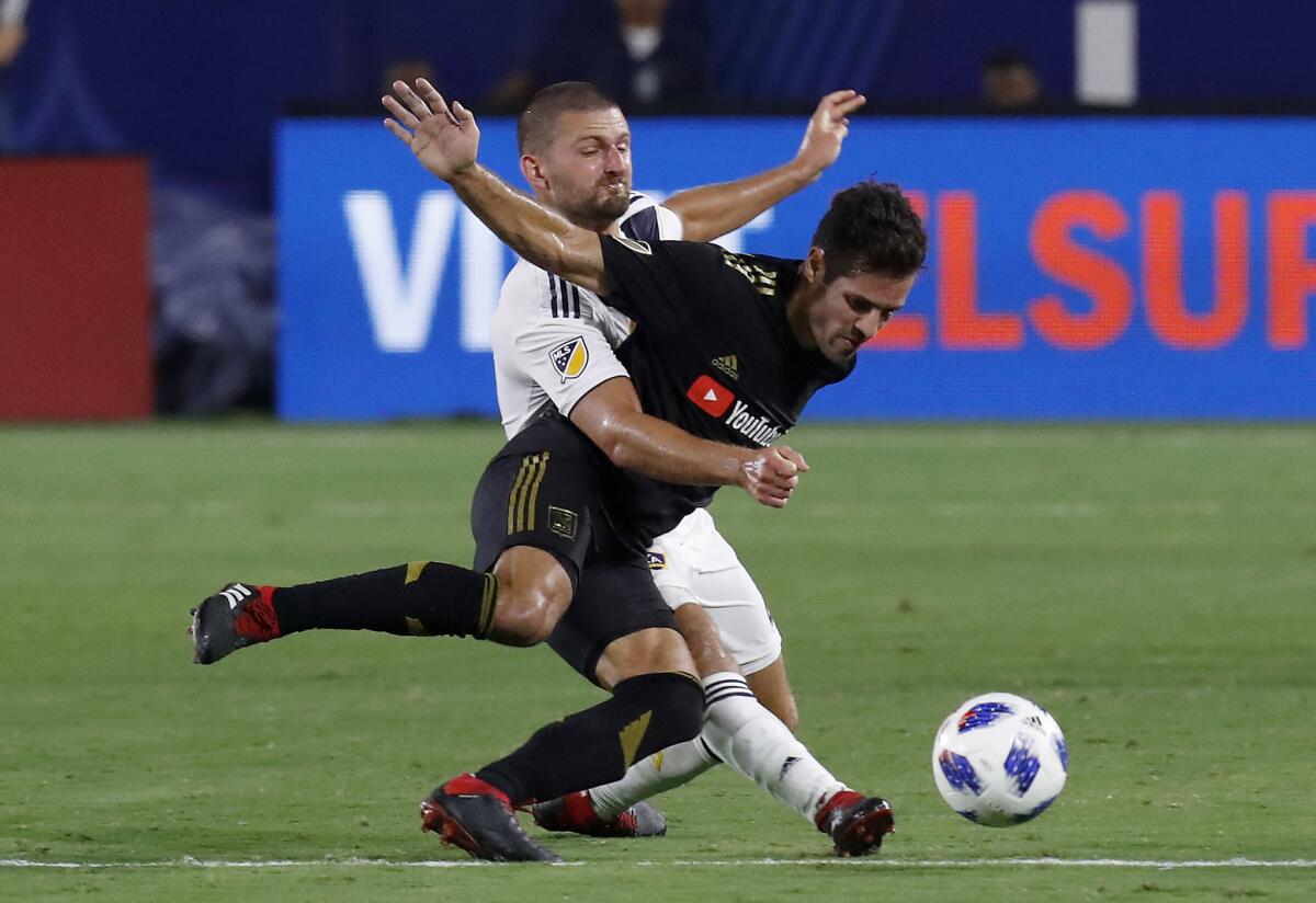 Galaxy midfielder Perry Kitchen, left, gets tangled up with LAFC defender Steven Beitashour on Aug. 24.