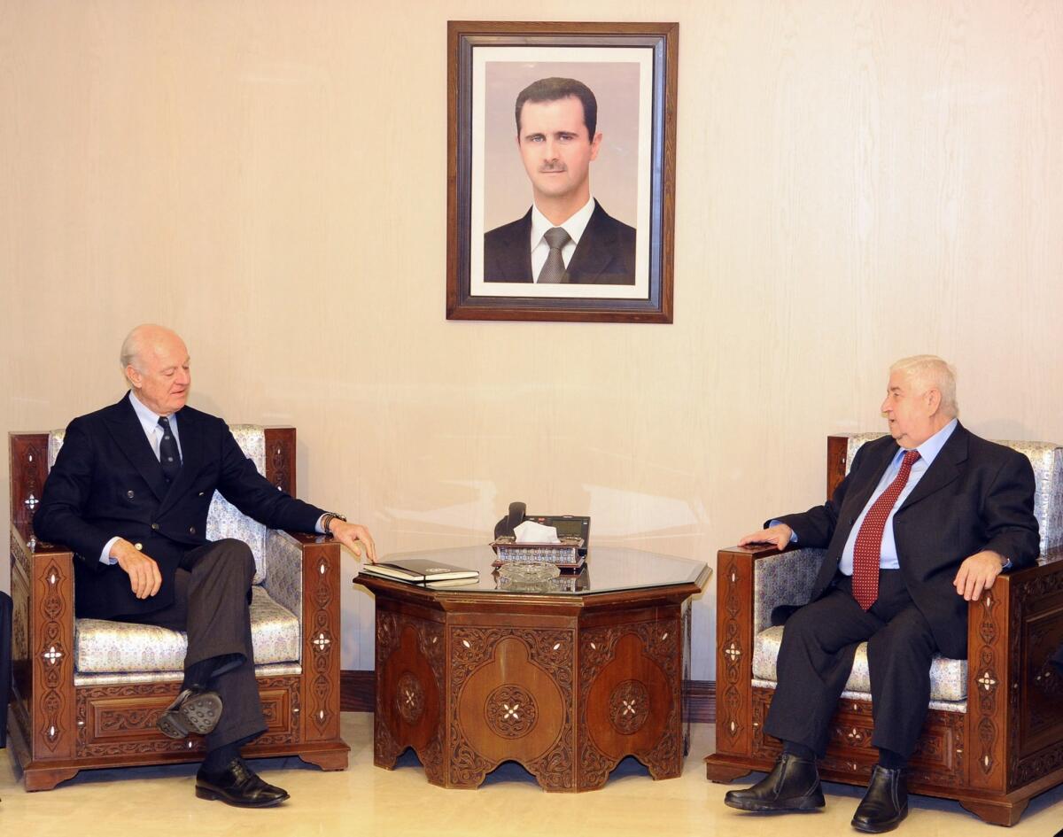 In this photo released by the Syrian official news agency SANA, Syria's foreign minister, Walid Moallem, right, meets with U.N. Special Envoy for Syria Staffan de Mistura in Damascus on Saturday.