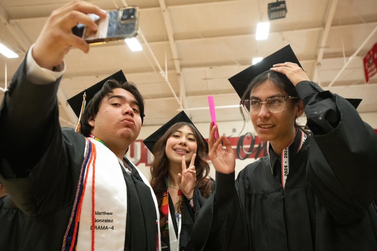 Matthew Gonzalez, Joselline Mendez and Jonathan Casillas pose for a selfie before graduating from Los Amigos High.