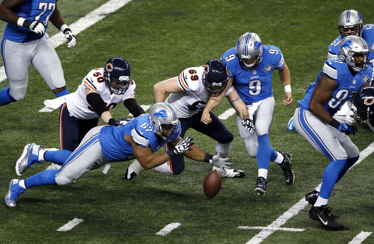 Detroit guard Rob Sims (67), Chicago defensive end Jared Allen (69) and Lions quarterback Matthew Stafford (9) try to recover a fumble during the teams' game on Thanksgiving Day.