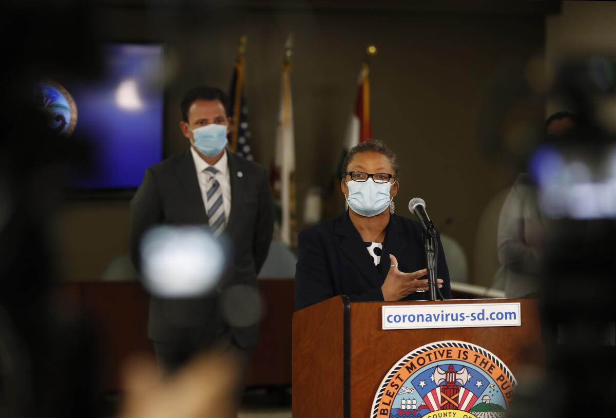 Dr. Wilma Wooten speaks as San Diego County Supervisor Nathan Fletcher looks on at a news conference on Monday.