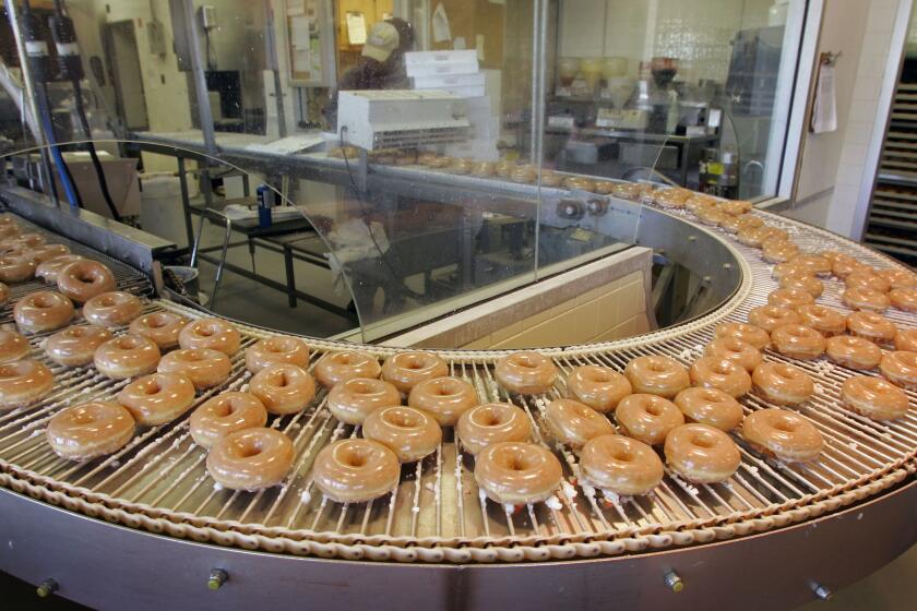 Glazed doughnuts roll by on a conveyer belt at a Krispy Kreme store in Charlotte, N.C.
