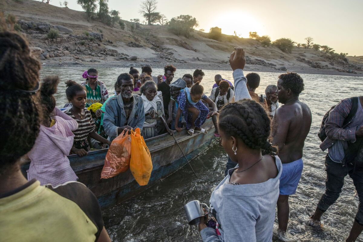 FILE - Tigrayan refugees arrive on the banks of the Tekeze River on the Sudan-Ethiopia border in Hamdayet, eastern Sudan on Dec. 2, 2020. A year after war began there, the findings of the only human rights investigation allowed in Ethiopia's blockaded Tigray region will be released Wednesday, Nov. 3, 2021. (AP Photo/Nariman El-Mofty, File)