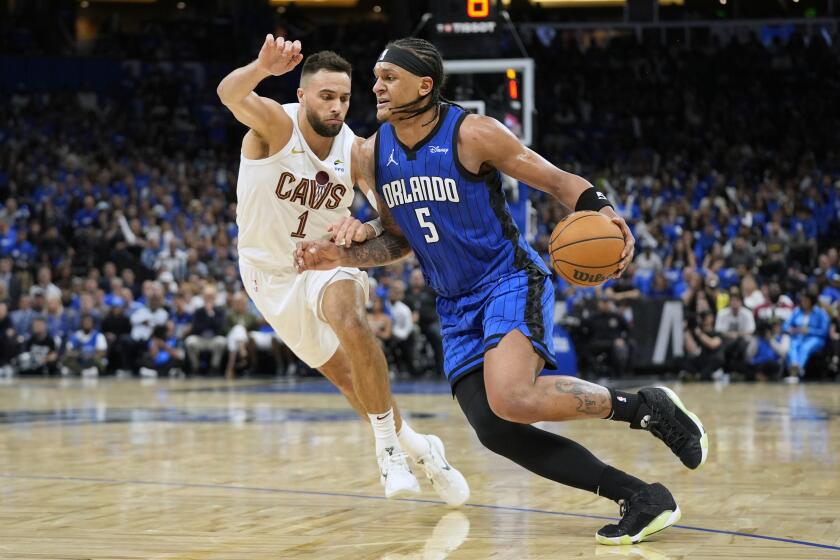 Orlando Magic forward Paolo Banchero (5) drives past Cleveland Cavaliers guard Max Strus (1) during the second half of Game 6 of an NBA basketball first-round playoff series, Friday, May 3, 2024, in Orlando, Fla. (AP Photo/John Raoux)