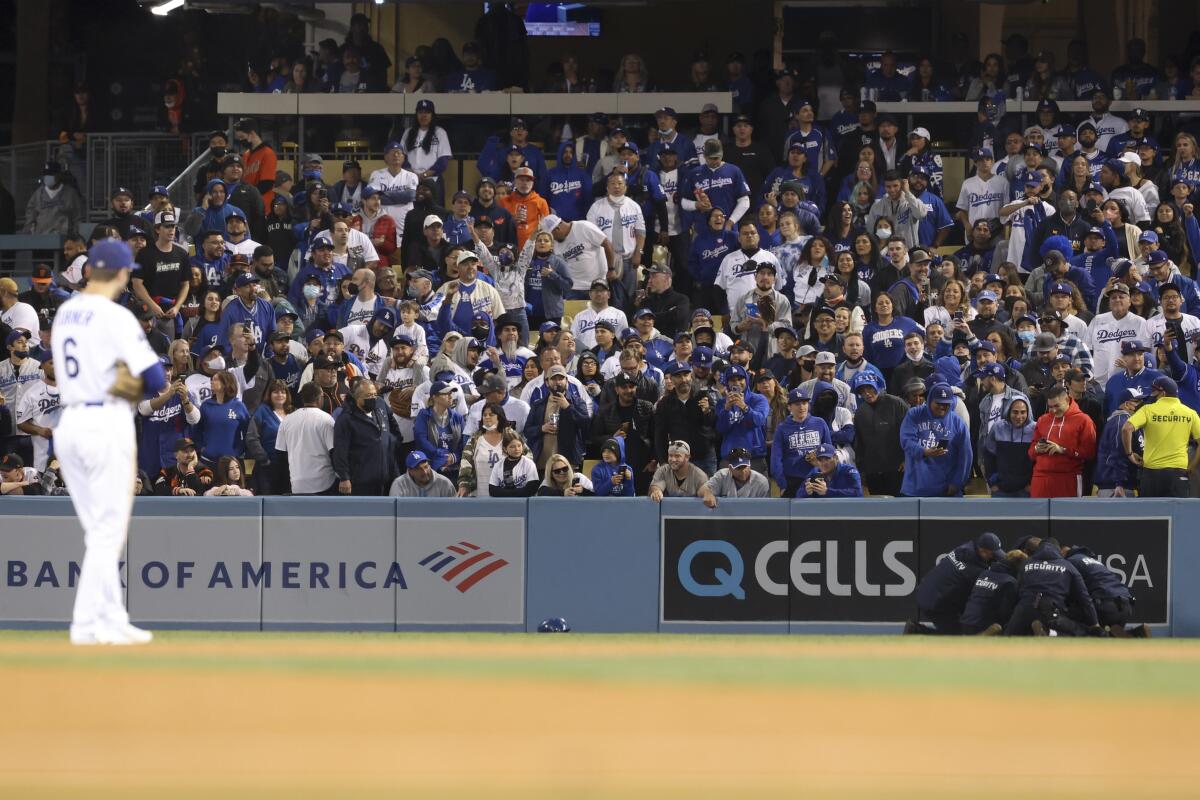A fan is apprehended by security after running onto the field at Dodger Stadium during the eighth inning.