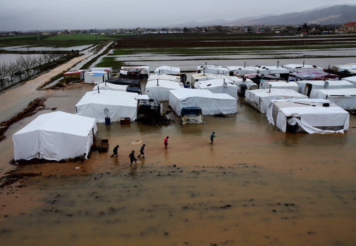 Syrian refugees make their way in flooded water at a refugee camp in the town of Faour near the border with Syria in Lebanon last week.