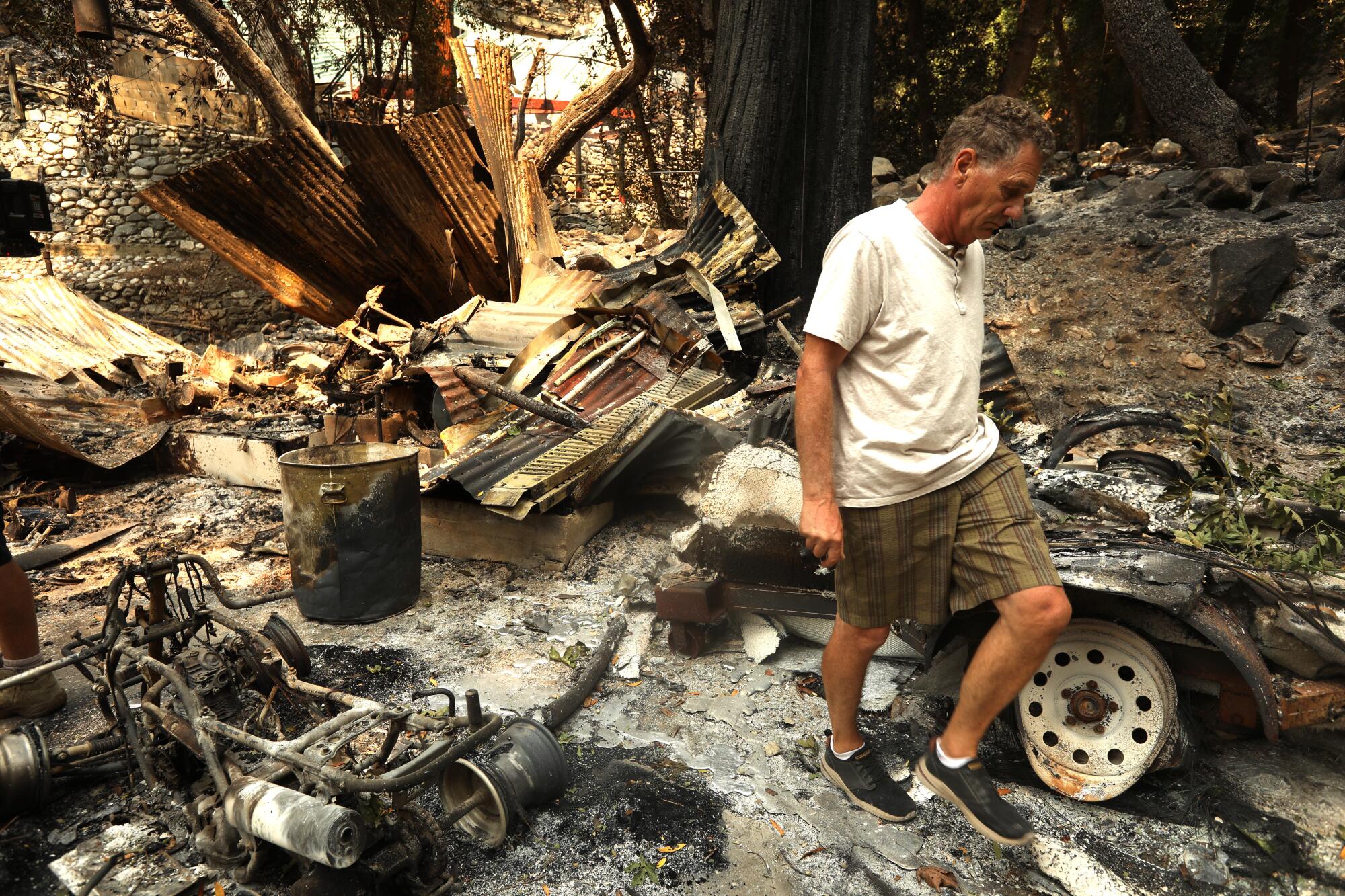 Paul Faulstich walks among the ruins of a property that was destroyed in the Bridge fire in Mount Baldy.