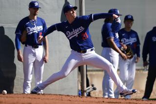 Los Angeles Dodgers pitcher Walker Buehler throws during the first day of spring training.
