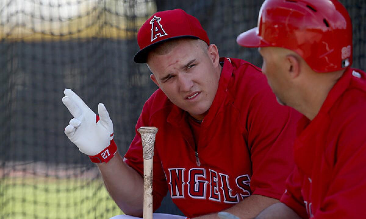 Angels outfielder Mike Trout, left, speaks with designated hitter Raul Ibanez during a spring training practice session Feb. 26. Trout is doing his best to stay focused on the upcoming season.