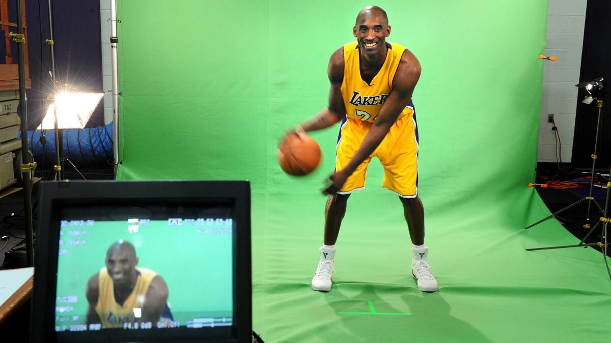 Lakers star Kobe Bryant dribbles a ball while videotaping a message during the team's media day in El Segundo on Monday.
