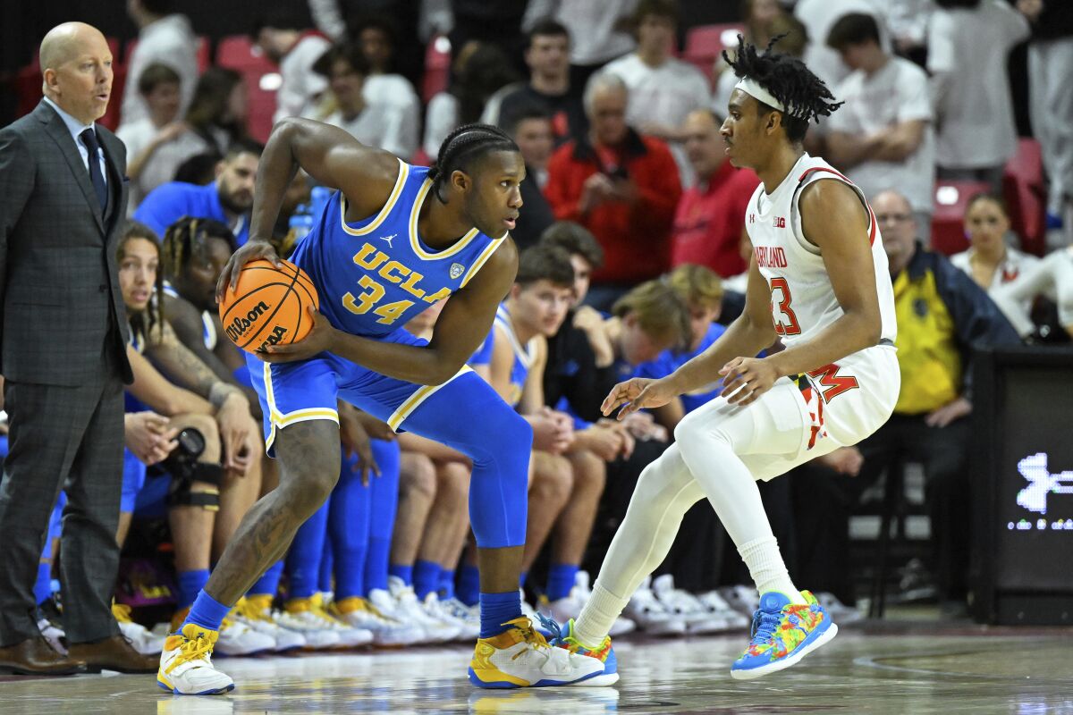 UCLA guard David Singleton holds the ball at his hop in front of Maryland guard Ian Martinez 