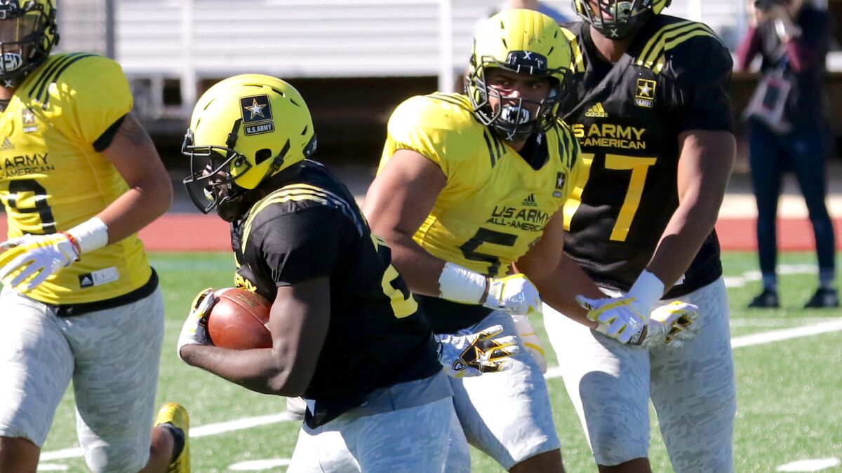 Defensive lineman Marlon Tuipulotu (51) of Independence Central in Oregon chases after running back Eno Benjamin during a West team practice leading up to the U.S. Army All-American Bowl in San Antonio.