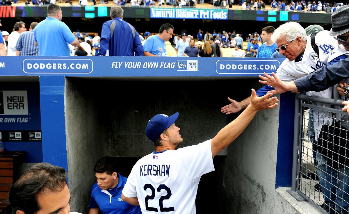 Dodgers' Clayton Kershaw celebrates a win on Opening Day with fans at Dodger Stadium.