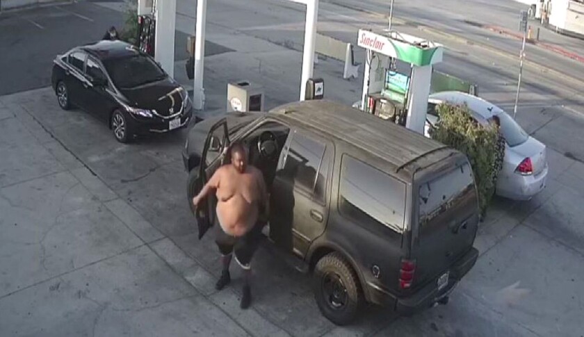 A shirtless Antoine Larue Rainey gets out of his car at a gas station in the West Rancho Domiguez area.
