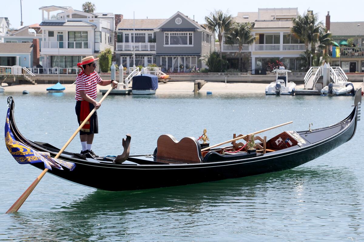Gondolier Eddie Rivera moves Bella, one of two new Venice-built gondolas, to make way for Luna.