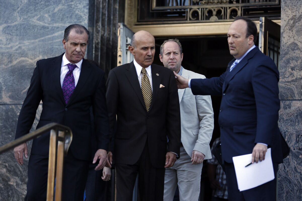 Retired Los Angeles County Sheriff Lee Baca, center, leaves the federal courthouse in downtown Los Angeles after pleading guilty Wednesday to lying to federal investigators.