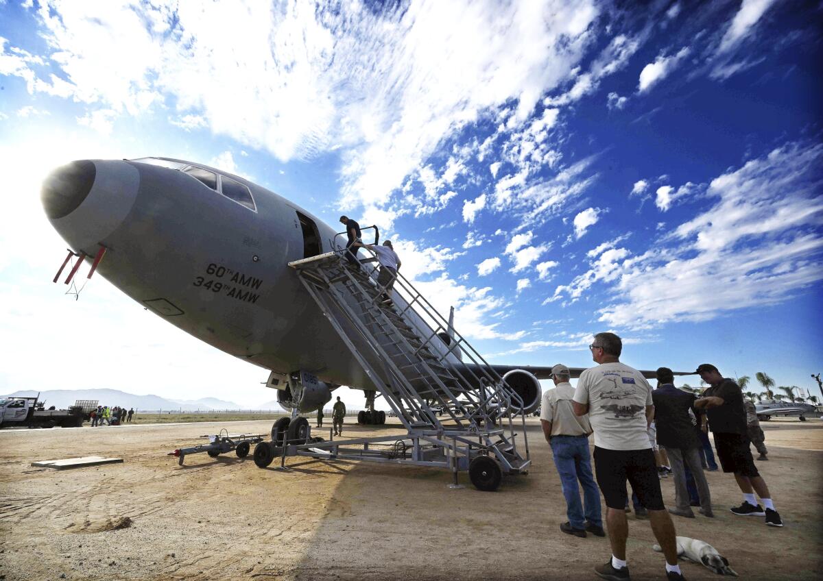 Visitors climb the stairs to board a plane.