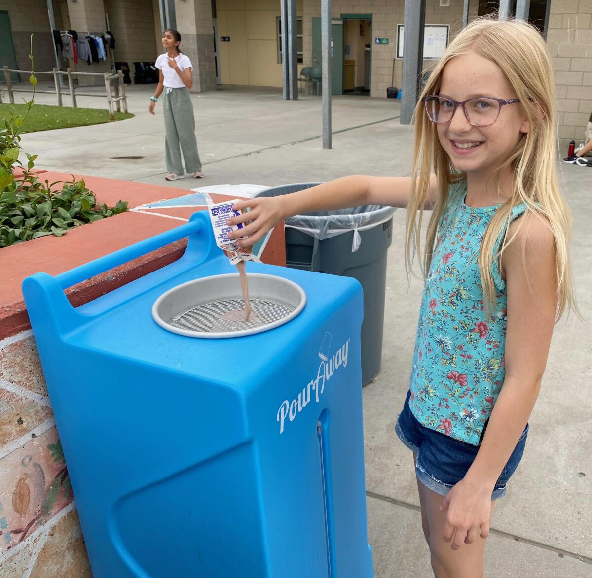 Oak Valley Middle School sixth-grader Evie Matthews uses the PourAway Station before recycling her milk carton.