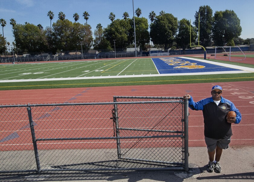 Crenshaw High football coach Robert Garrett stands next to the football field.