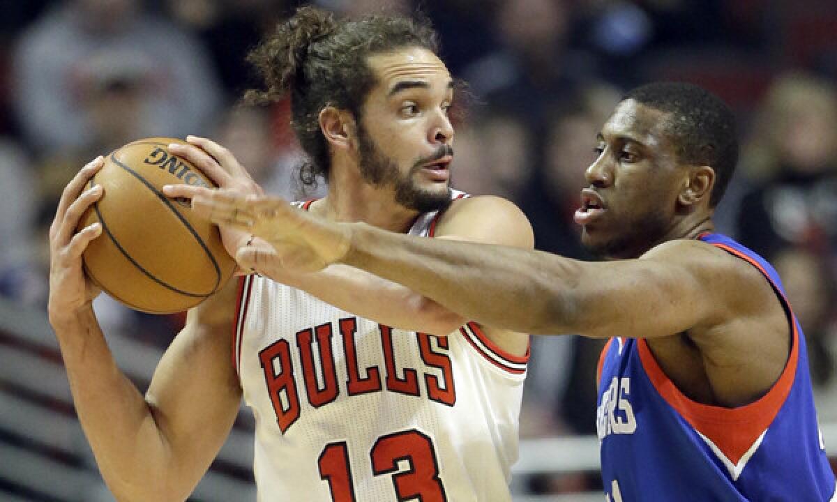 Chicago center Joakim Noah tries to pass around Philadelphia 76ers forward Thaddeus Young during the Bulls' 103-78 win Saturday. The Lakers look to extend their winning streak to three games Monday against Chicago.