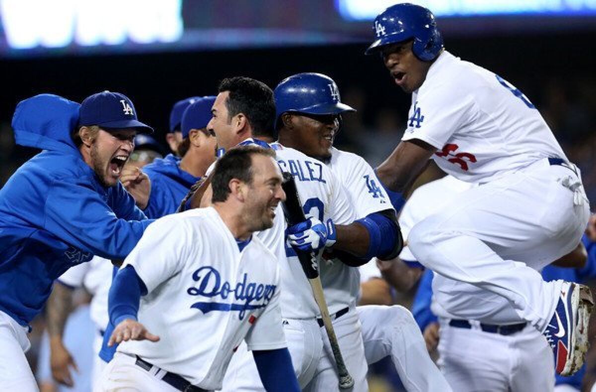 Dodgers first baseman Adrian Gonzalez is mobbed by teammates after scoring the winning run against the Tampa Bay Rays in the ninth inning Friday night at Dodger Stadium.