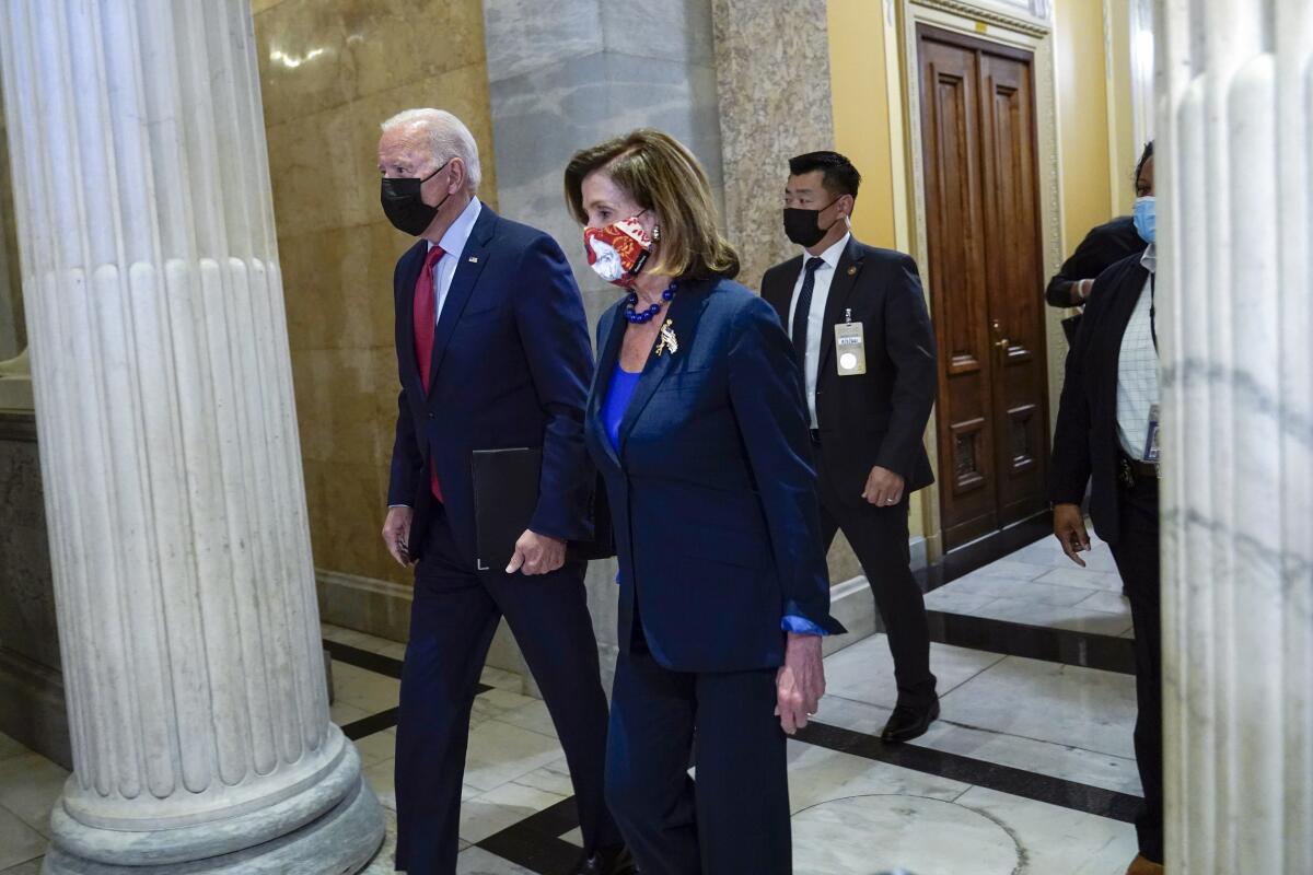 President Biden walks with House Speaker Nancy Pelosi on Capitol Hill.