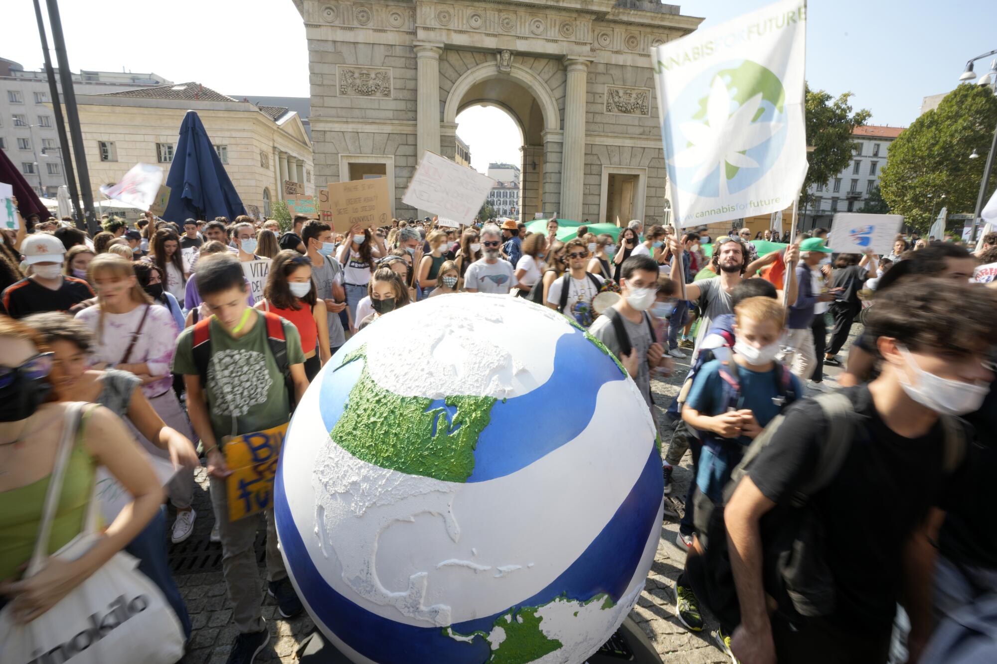 A large globe is used in a street protest.