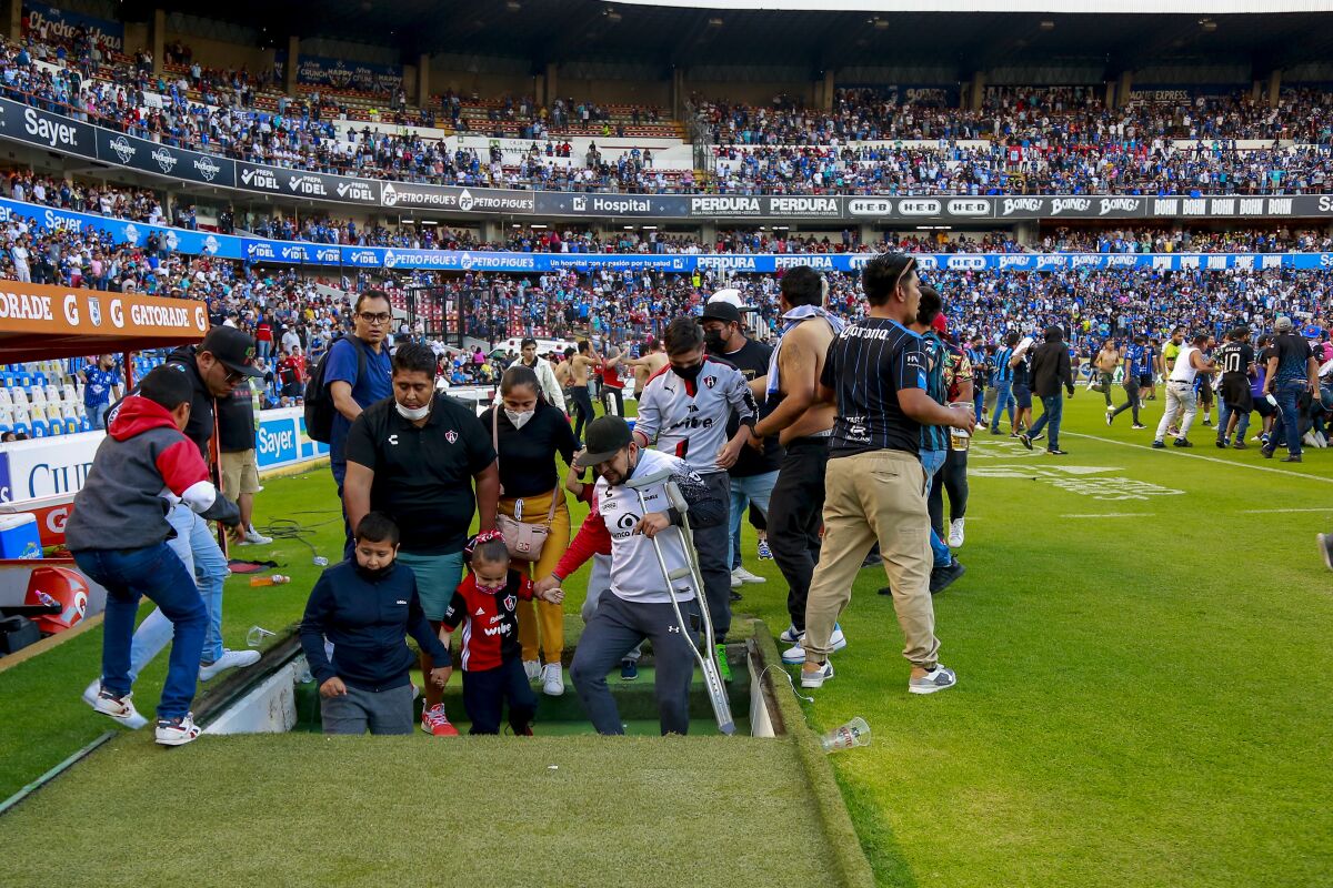 Fans of Queretaro and Atlas clash during a Mexican soccer league match at the Corregidora stadium,