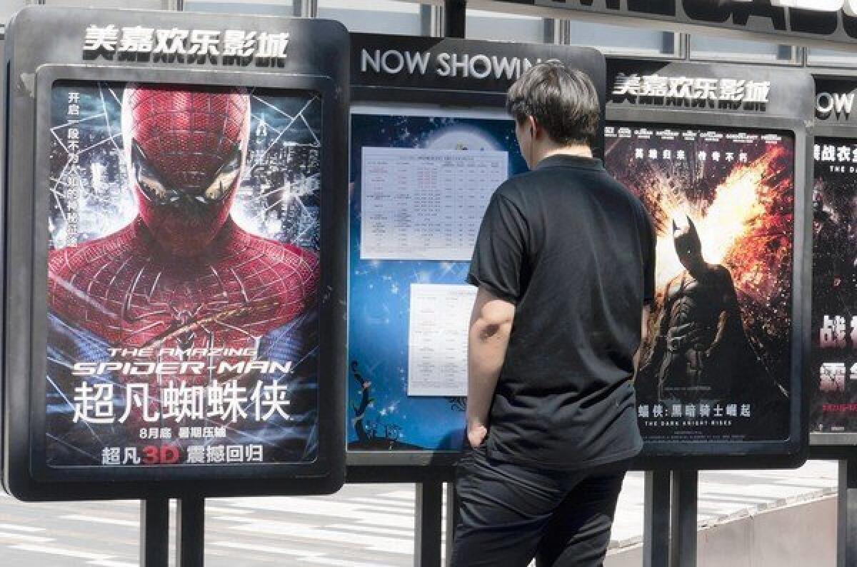 Hollywood blockbuster movies "The Amazing Spider-Man" and "The Dark Knight Rises" are advertised as coming at the end of August in central Beijing.