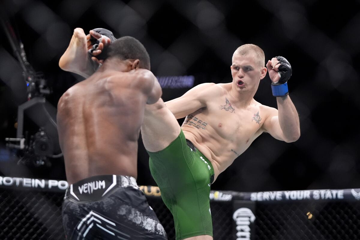 Ian Garry, right, kicks Geoff Neal during their welterweight bout at UFC 298.