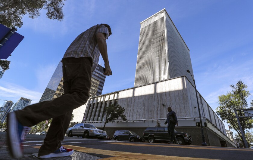 Pedestrians cross A Street with the former Sempra building in the background 