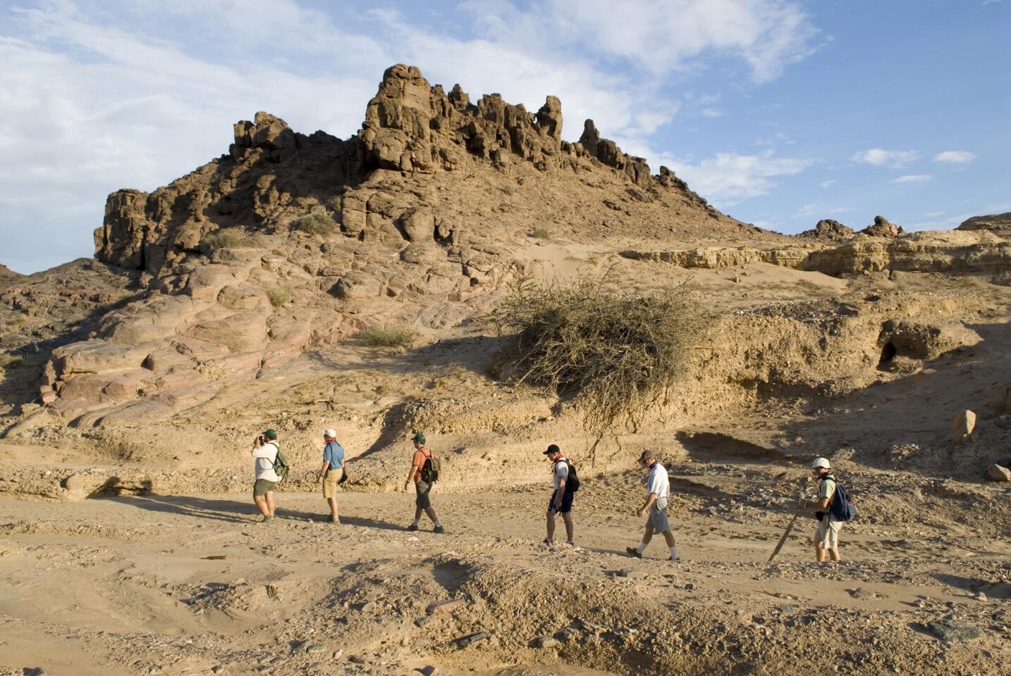 Tourists on a guided hike by Hoanib River, near Hoanib Camp in Kaokoland, Namibia.