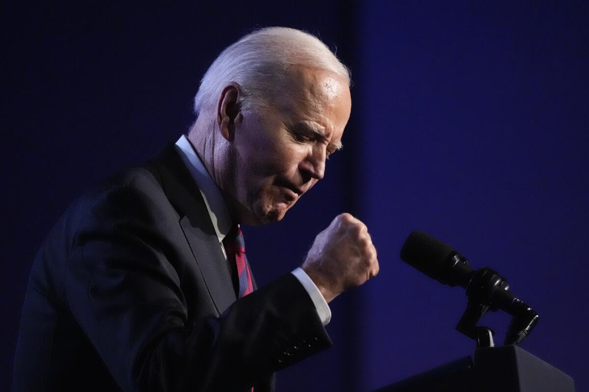 President Biden with clenched fist, speaking into a microphone 