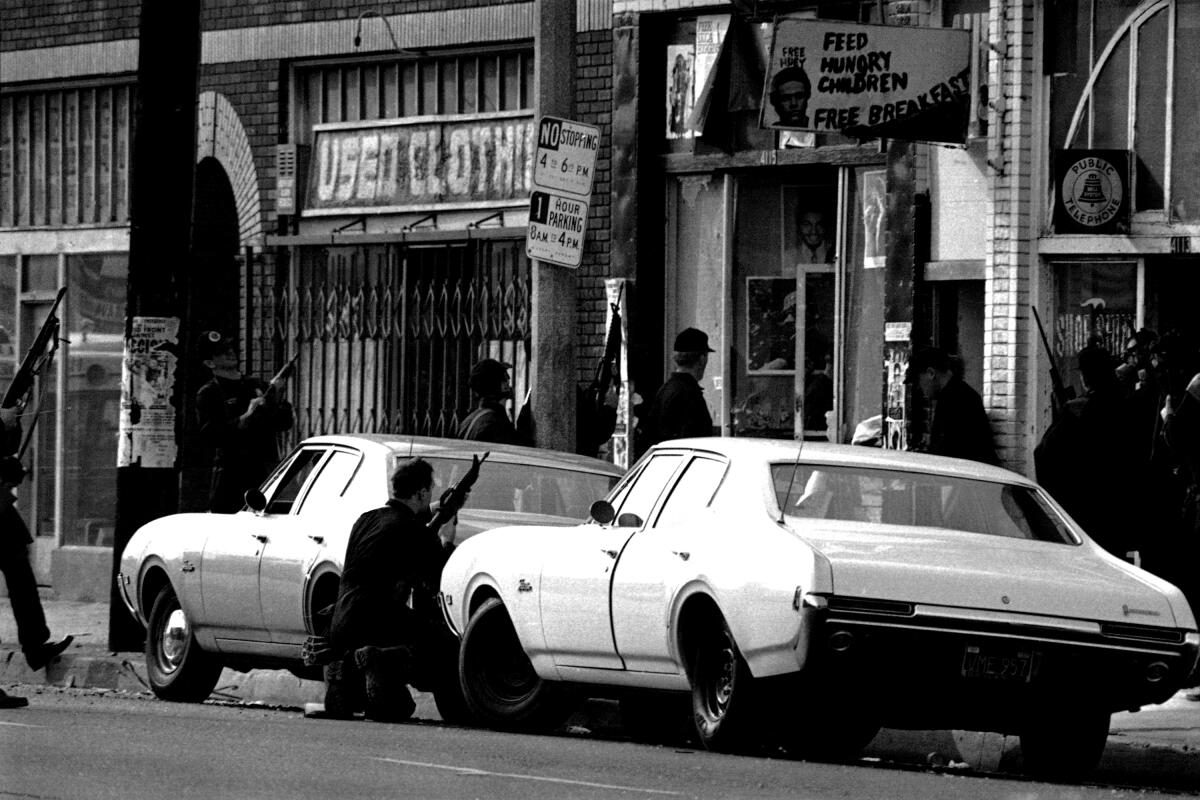 Some of more than 300 policemen provide cover as officers enter the Los Angeles Black Panther headquarters in Los Angeles on Dec. 8, 1969 following a four-hour siege.